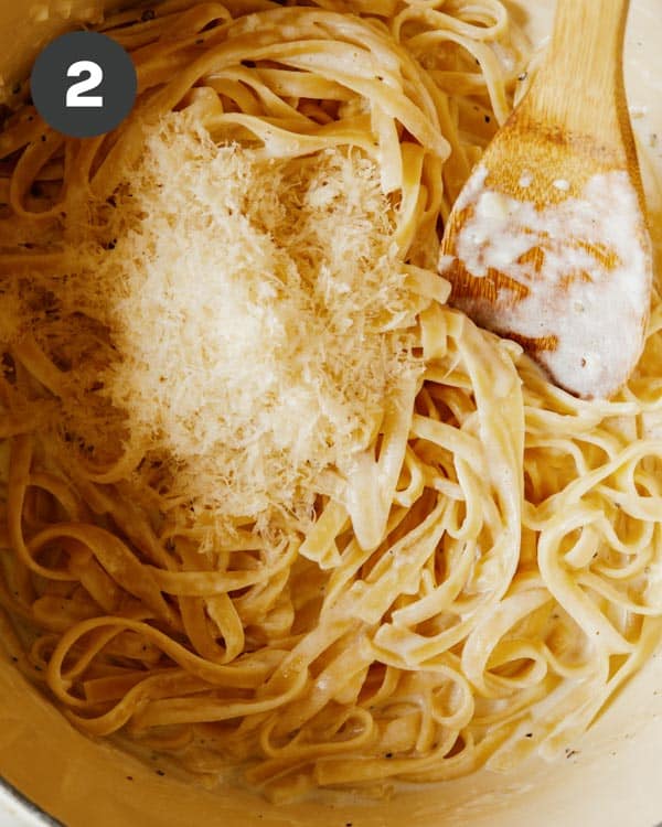 Fettuccine alfredo with fresh parmesan on top to be mixed in.