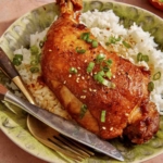 Braised chicken on a plate with rice.