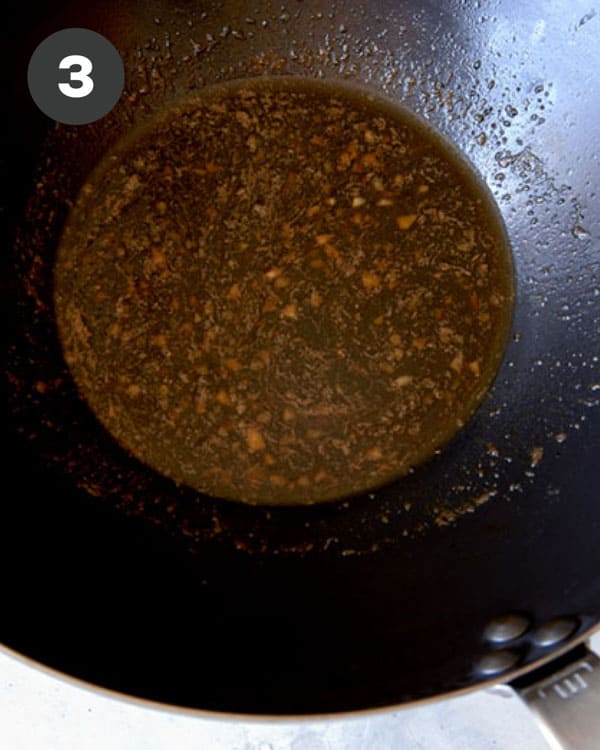 Fish sauce and soy sauce in a wok with garlic and butter.