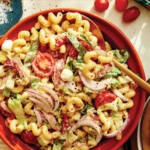 Grinder pasta salad in a bowl with ingredients on the side.