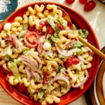 Grinder pasta salad in a bowl with ingredients on the side.