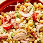 Grinder pasta salad up close with a spoon in the bowl.