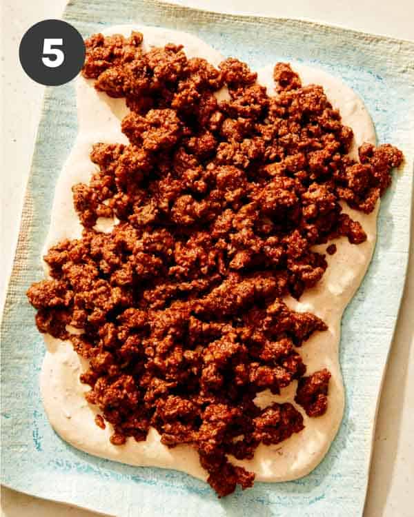 Sour cream with ground beef on top for taco dip.