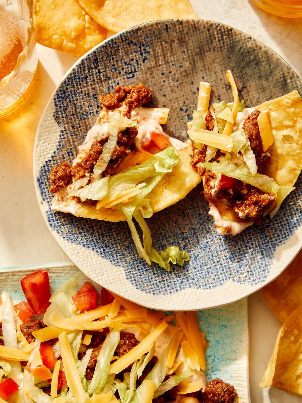 Taco dip with chips dipped into it on a plate. 