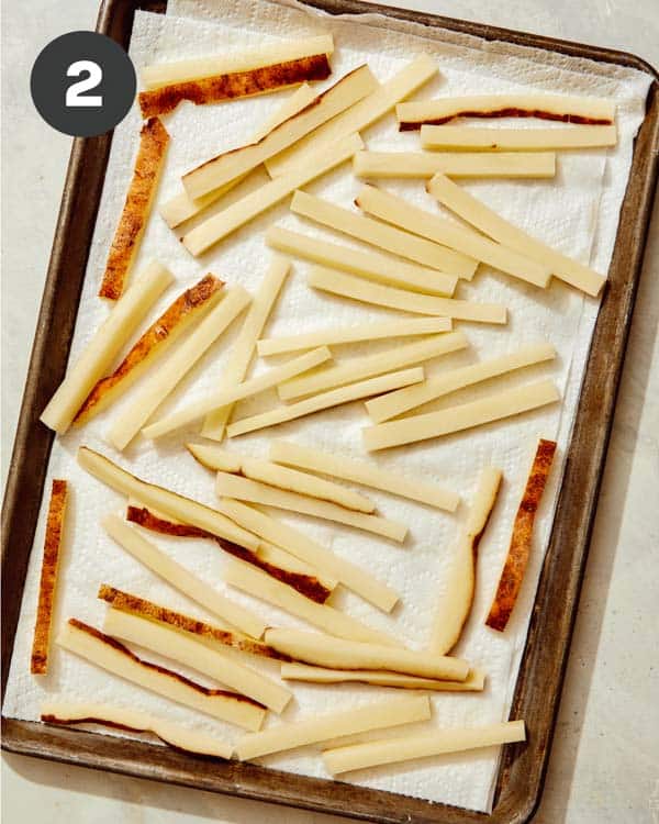 Cut french fries drying on paper towels. 