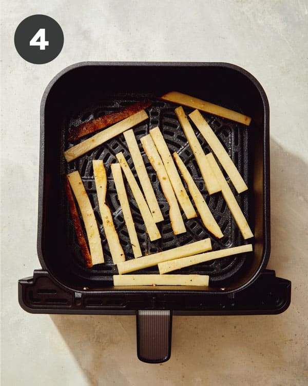 French fries laid out in an air fryer. 