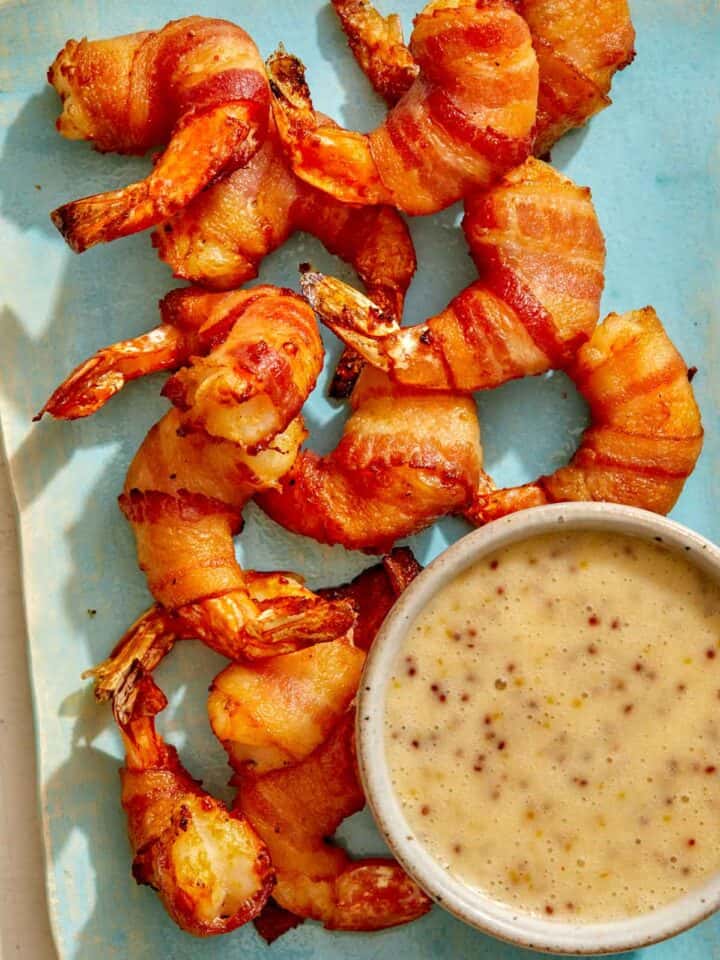 Air fryer bacon wrapped shrimp on a platter with honey mustard.