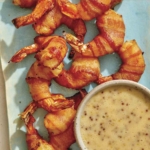 Air fryer bacon wrapped shrimp on a platter with honey mustard.