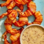 Air fryer bacon wrapped shrimp on a platter with honey mustard.