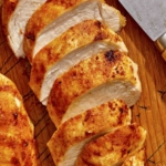 Air fryer chicken breast on a cutting board.