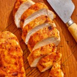 Air fryer chicken breasts on a cutting board.