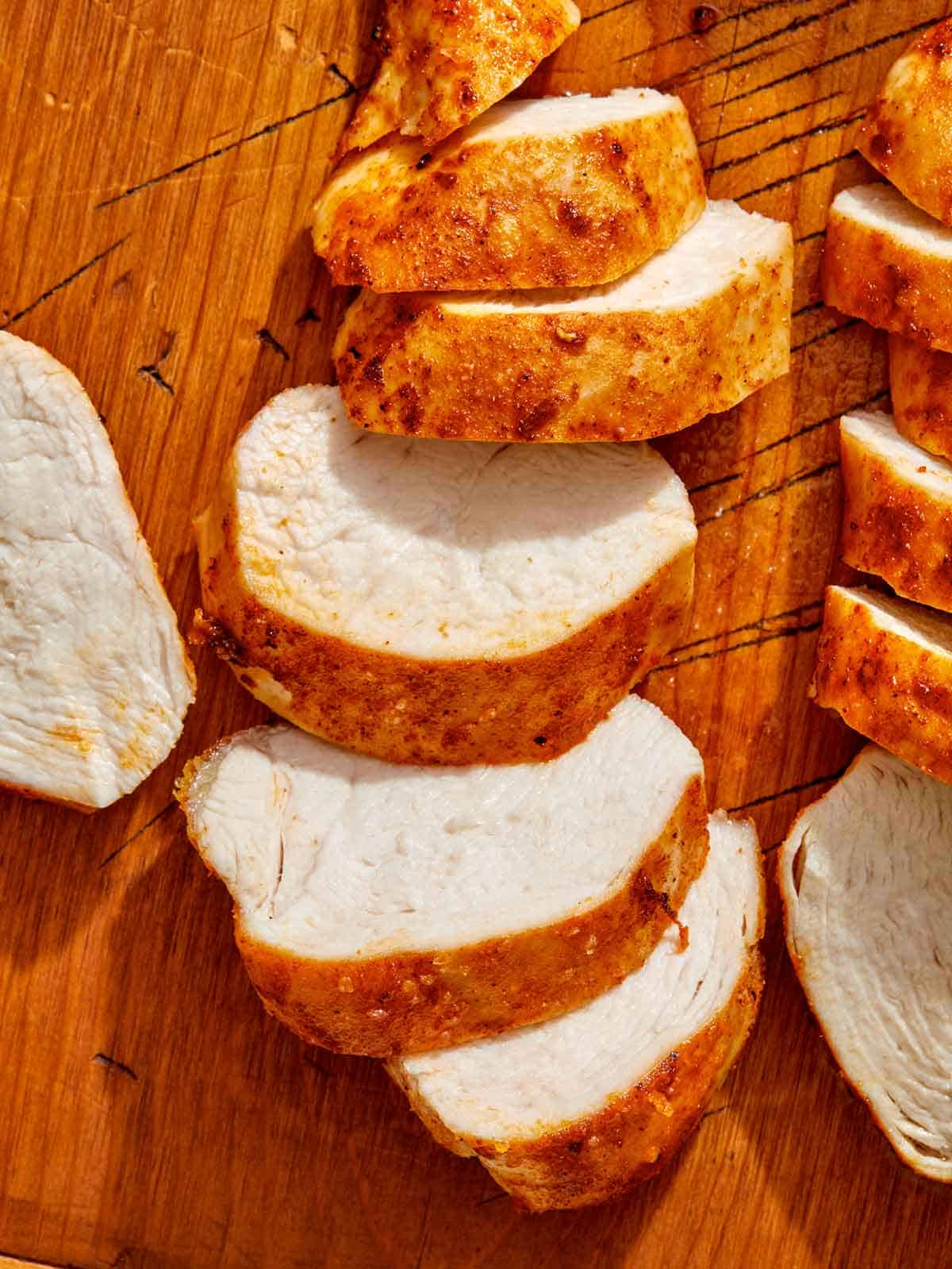 Air fryer chicken breast on a cutting board. 