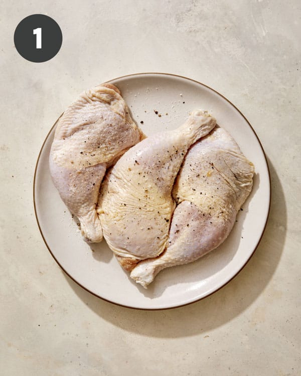 Seasoned chicken quarters on a plate. 