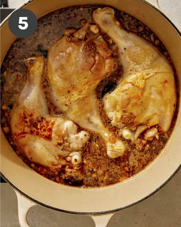Chicken in sauce in a pot to be braised in the oven.