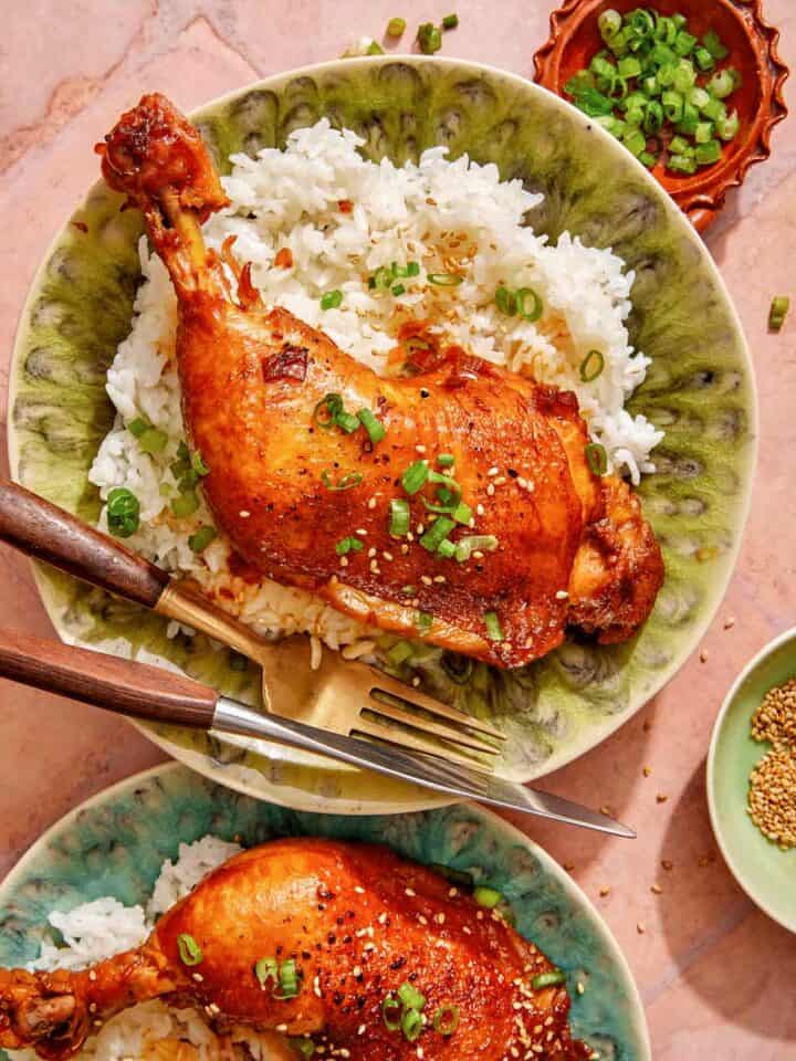 Garlic and ginger braised chicken recipe on two plates with rice.