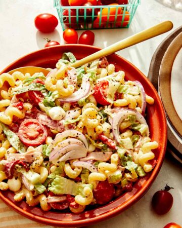 Grinder pasta salad in a bowl with a spoon in it.