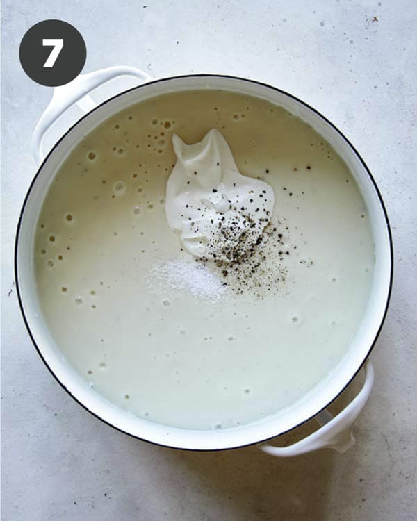 Loaded baked potato soup in a stock pot with sour cream added.