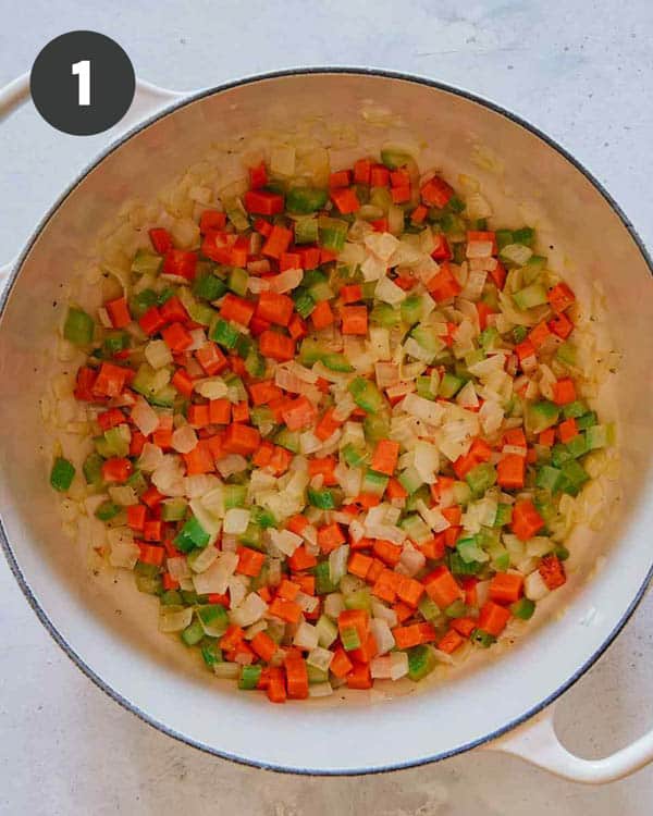 Onions, celery, and carrots in a stock pot sautéing with butter.