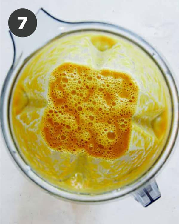 Pumpkin soup mixture in a blender shot overhead.
