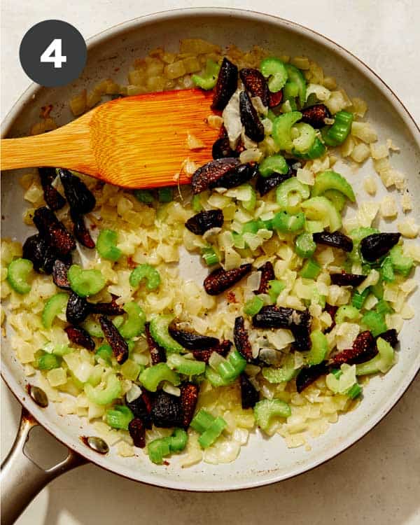 A skillet cooking stuffing ingredients. 