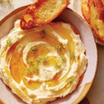 Whipped brie recipe in a bowl with honey.