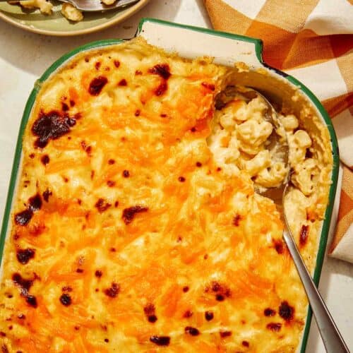 Baked mac and cheese recipe with a scoop out of it.