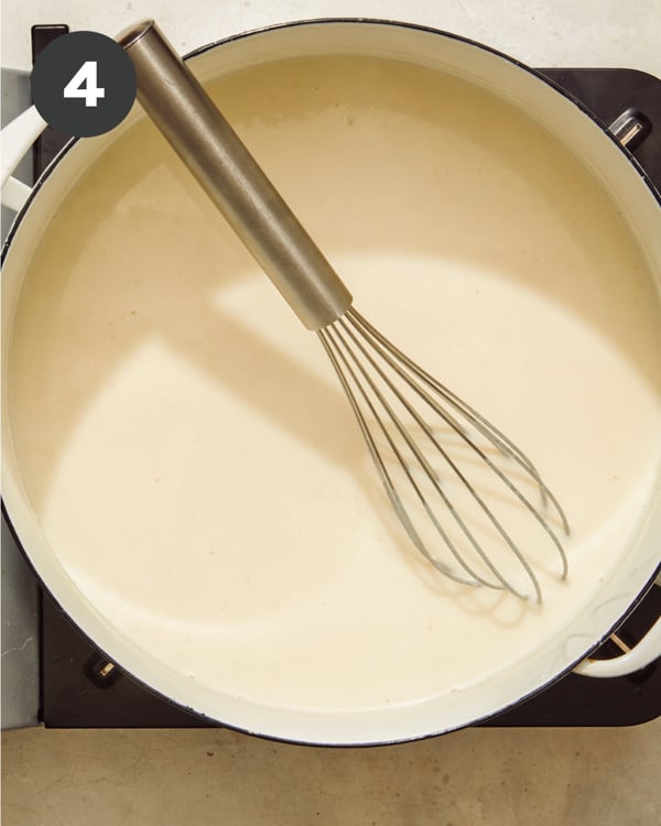 Baked mac and cheese sauce cooking on a stove. 