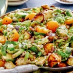 Shaved brussel sprout salad recipe in a bowl with a spoon.