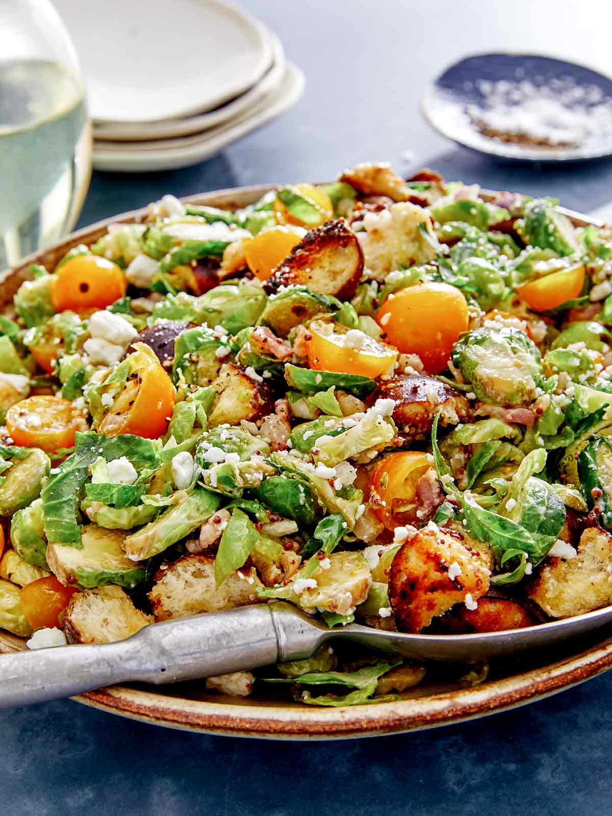 Shaved brussel sprout salad recipe in a bowl with a spoon. 