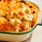 Baked mac and cheese with a scoop being taken out of it.