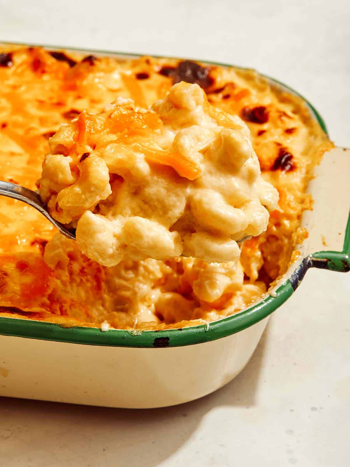 Baked mac and cheese with a scoop being taken out of it.