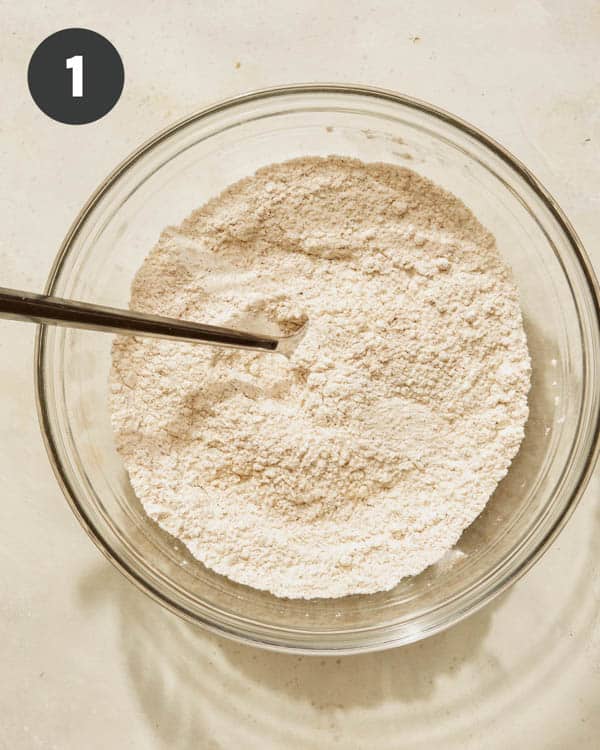 Flour mixture in a bowl whisked together for pumpkin waffles.