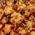 Sausage stuffing recipe in a casserole dish with a scoop out.