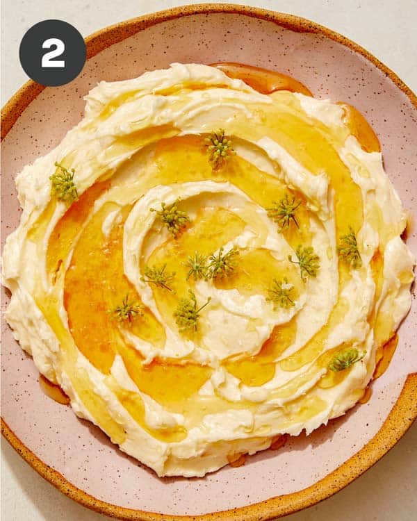 Whipped brie in a bowl with honey on top.