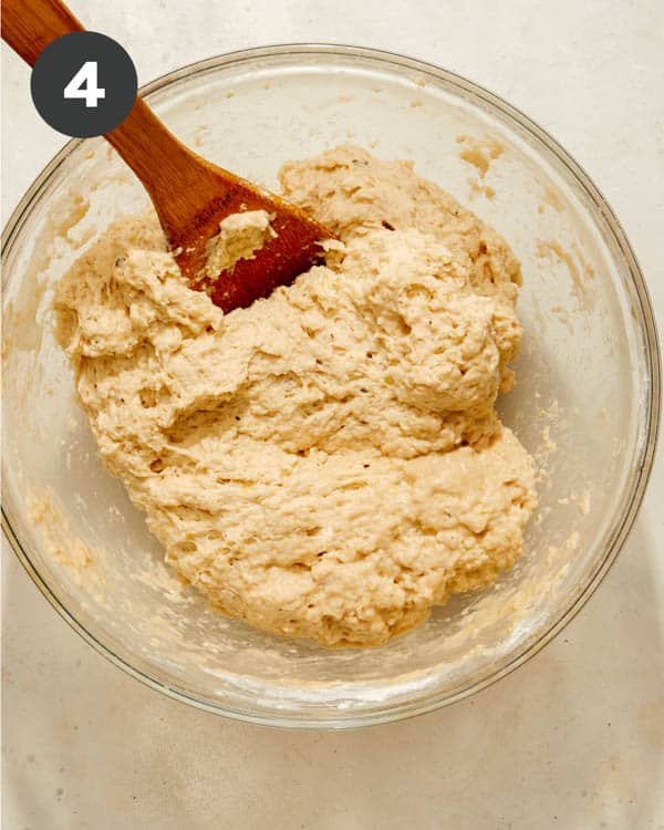 Beer bread dough in a bowl with a spoon in it. 