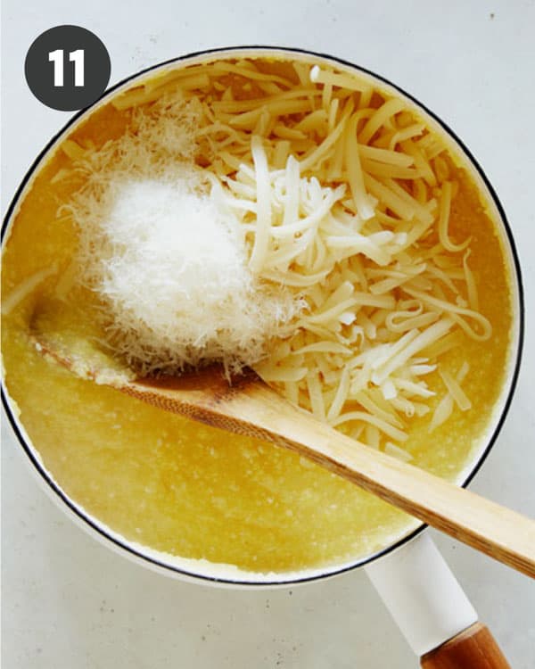 Polenta in a pot with cheese being mixed in.