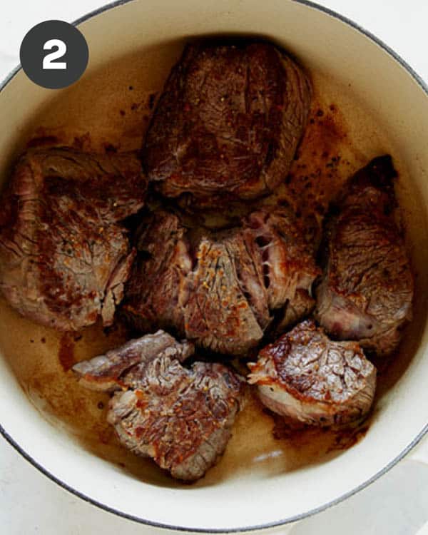 Seared beef in a stock pot overhead.