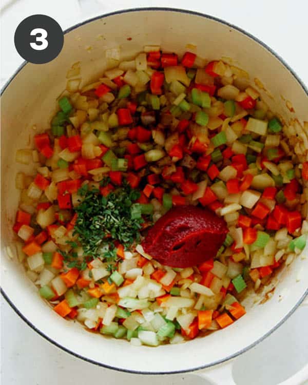 Sauted veg with tomato paste and herbs in a stock pot.