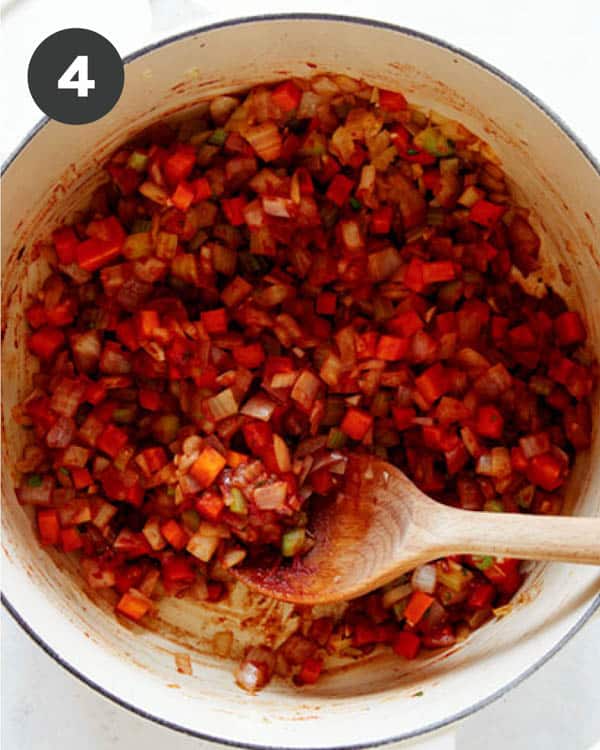 Vegetable and tomato paste in a stock pot.