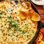 Corn dip in a skillets with chips on the side.