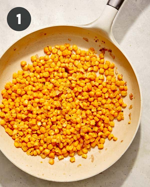 Corn in a skillet with shallots and butter.