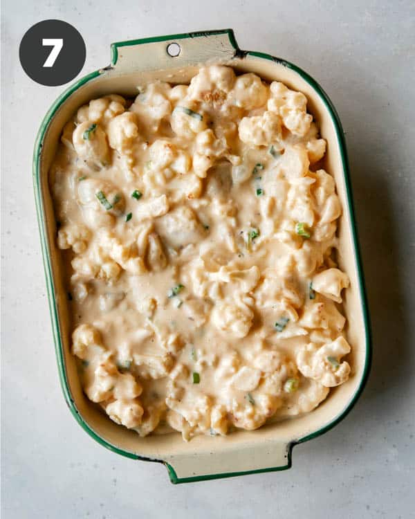 Creamy baked cauliflower in a baking dish ready to be baked. 