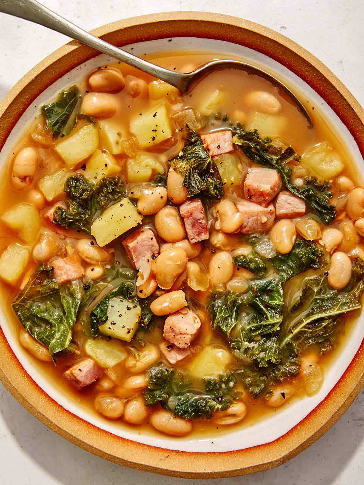 One bowl of white bean and kale soup up close. 