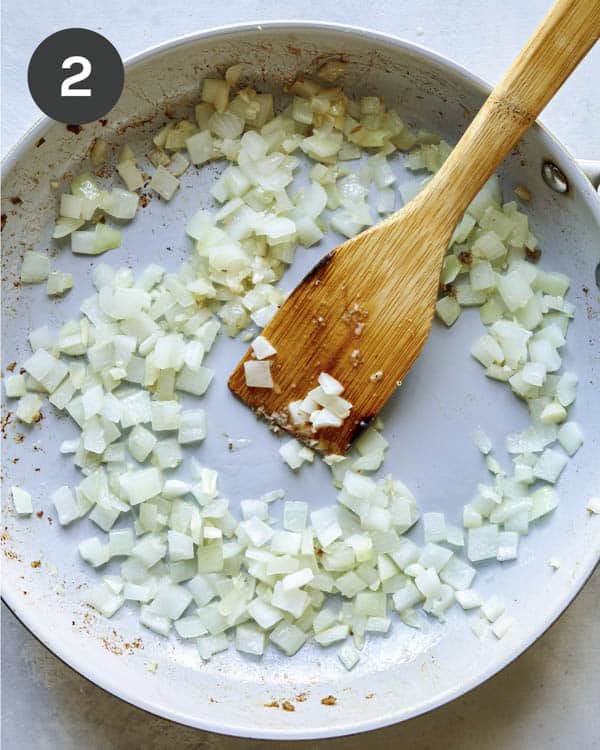 Onions and garlic cooking in a skillet.