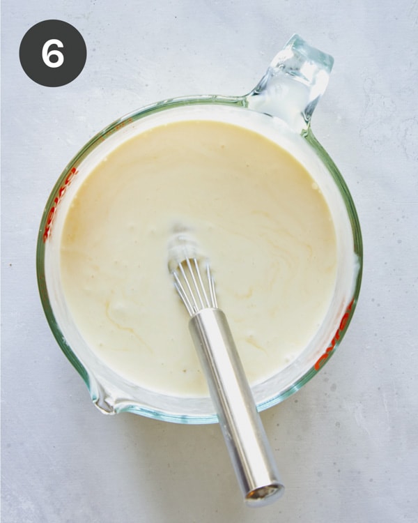 Eggs and cream whisked together in a bowl.