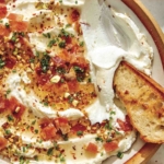 Whipped goat cheese with a crostini dipped in it.