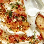 Whipped goat cheese with a crostini dipped in it.