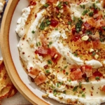 Whipped goat cheese in a bowl with crostini on the side.