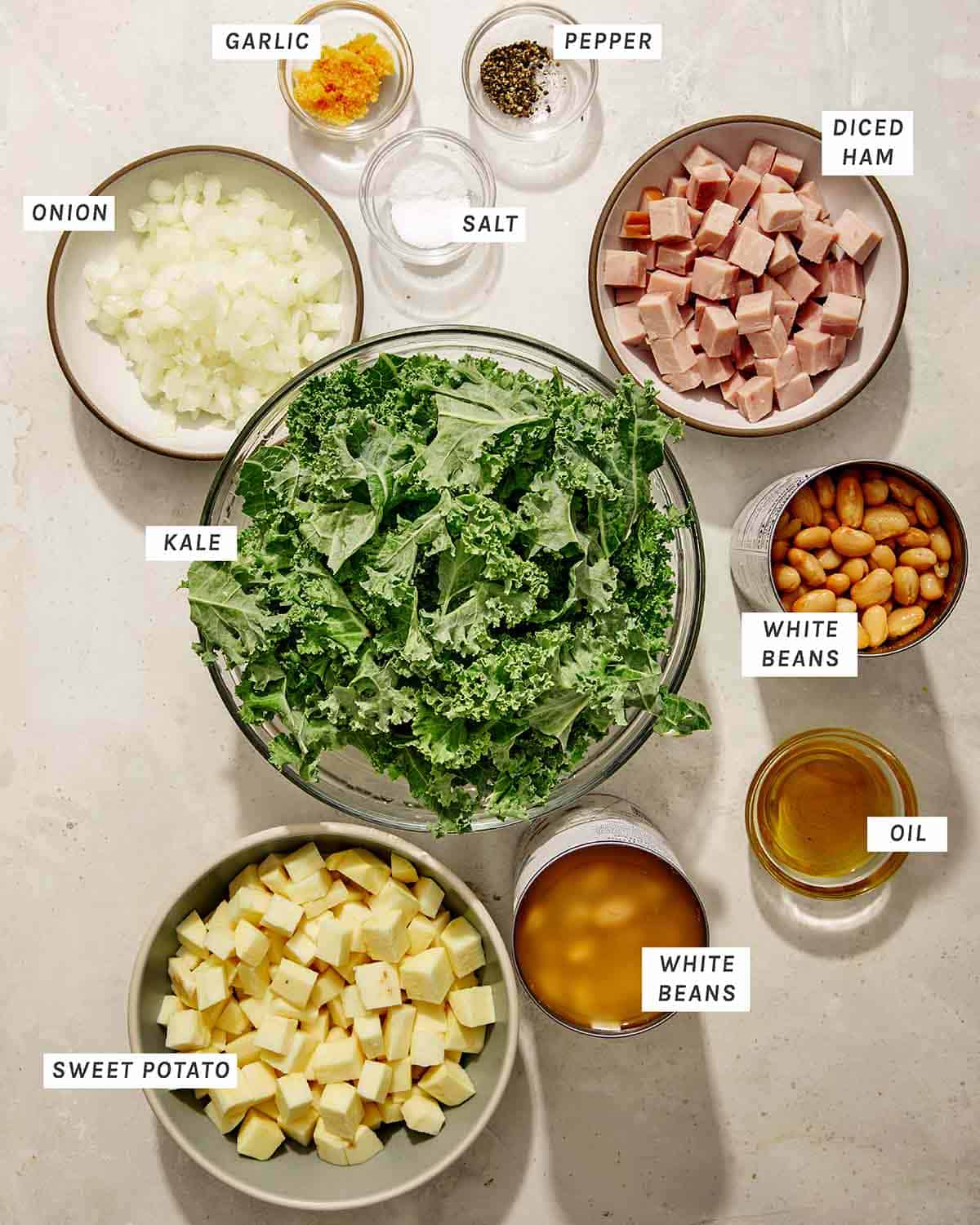 White bean and kale soup ingredients on a kitchen counter to make a soup recipe. 