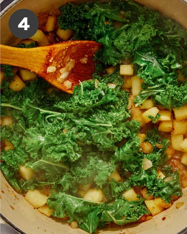 White bean soup ingredients cooking in a pot. 